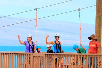 a man standing on top of a wooden fence